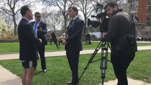 BBC Alun Cairns MP in suit and running shorts