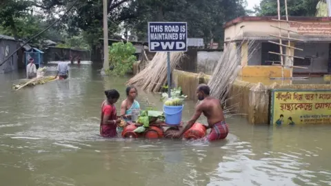 AFP People wade through floodwater in Balurghat in West Bengal, India (17 Aug 2017)