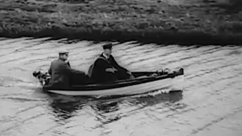 A postman in a boat in Cambridgeshire in 1951