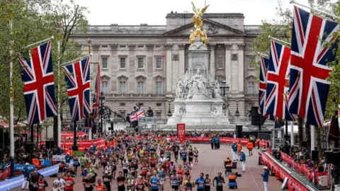 Getty Images Runners heading down The Mall during the 2019 London Marathon with Buckingham Palace in the background