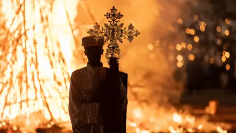 Amanuel Sileshi/AFP A deacon in front of a Meskel bonfire in Addis Ababa, Ethiopia - Wednesday 27 September 2023