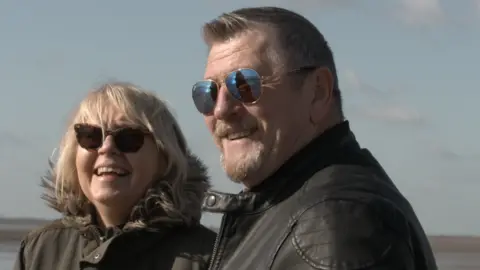 Jamie Niblock/BBC Maria and Don Miles smiling while standing on Southend Sea front