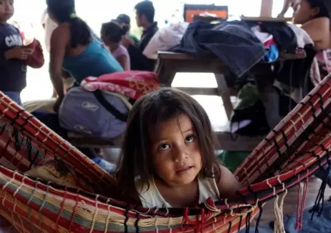 Reuters A girl rests in a hammock as her family sets up camp during the protest march.