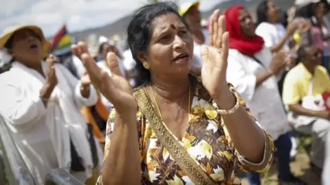 EPA A Hindu woman sings and prays during a mass led by Pope Francis at the Monument of Mary Queen of Peace in Port Louis, Mauritius, 09 September 2019.