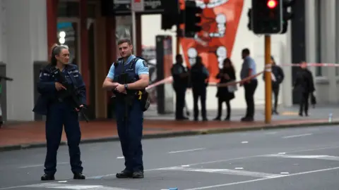 EPA Police stand guard at a cordoned off area near the site of a shooting in Auckland, New Zealand