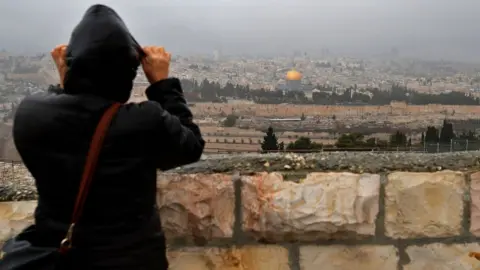 AFP Person looks over at the Old City of Jerusalem on 6 December 2017