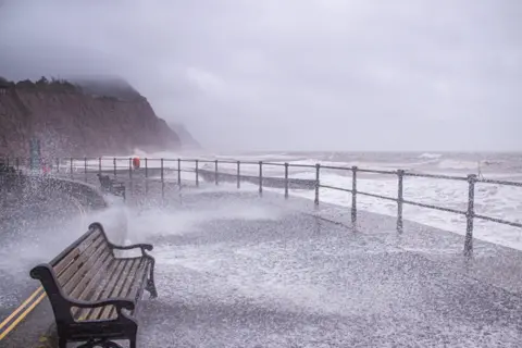 Alamy The sea bursts on to a deserted esplanade at Sidmouth, Devon