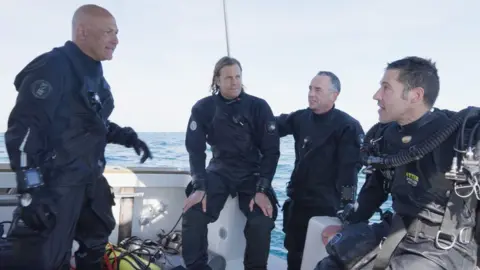 The Hunt for Lady Olive and the German Submarine Divers Karl Taylor, Peter Frankland, Chris de Putron and Nathan Martel out at sea on a boat