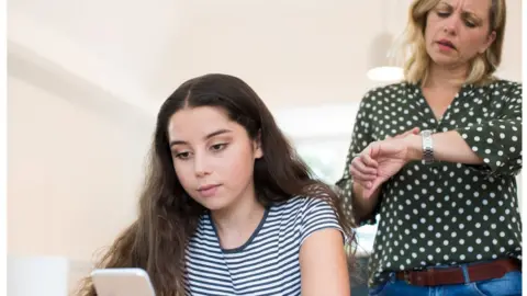 Getty Images Mum getting annoyed about daughter's use of social media