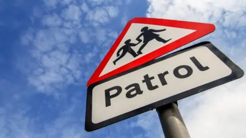 Getty Images School children crossing patrol sign