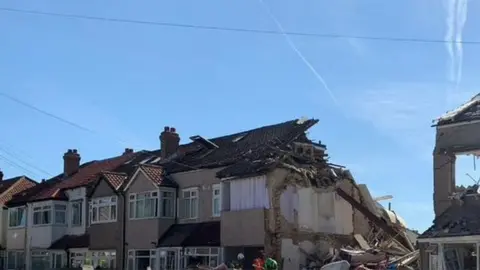 London Fire Brigade A terraced house has collapsed following an explosion and neighbouring properties have also been damaged.