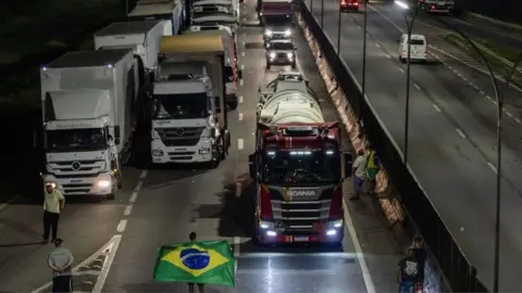 Reuters Supporters of Brazilian President Jair Bolsonaro block a road with lorries in Jacareí , São Paulo state. Photo: 31 October 2022