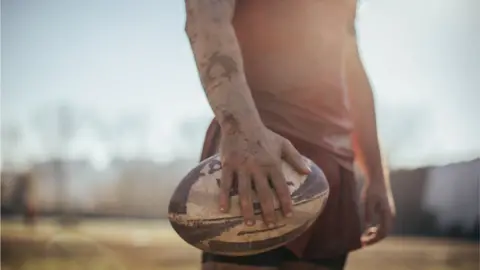 South_agency/Getty Creative Rugby player holding ball