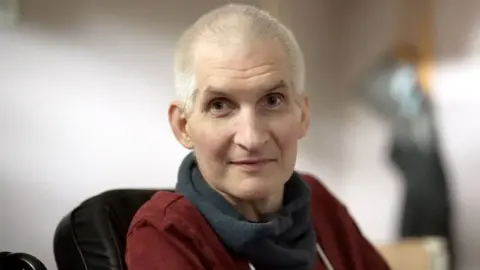 Stephen Fildes A man with short white hair looks at the camera