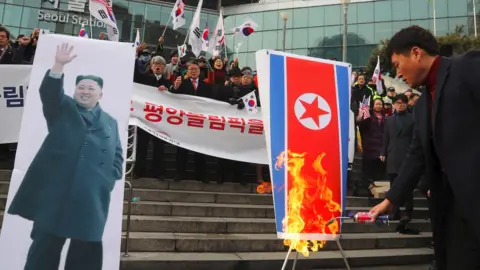 AFP/Getty Images South Korean protesters burn a North Korean flag (R) and a picture (L) of North Korean leader Kim Jong-Un during an anti-North Korea rally