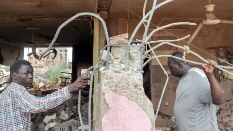 Getty Images People inspect the rubble at a house that was hit by an artillery shell in the Azhari district in the south of Khartoum on June 6, 2023