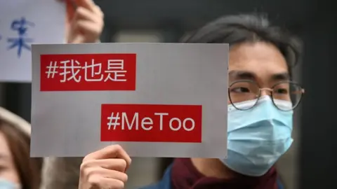 Getty Images Supporters of Zhou Xiaoxuan, a feminist figure who rose to prominence during Chinas #MeToo movement two years ago, display posters outside the Haidian District Peoples Court in Beijing on December 2, 2020, in a sexual harassment case against one of China's best-known television hosts.