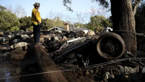 Getty Images Rescue worker surveys debris after deadly mudslide in California. 10 Jan 2018