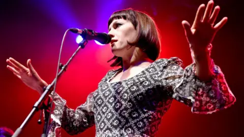 Getty Images | Shirlaine Forrest Gwenno singing on stage back-lit with red lighting