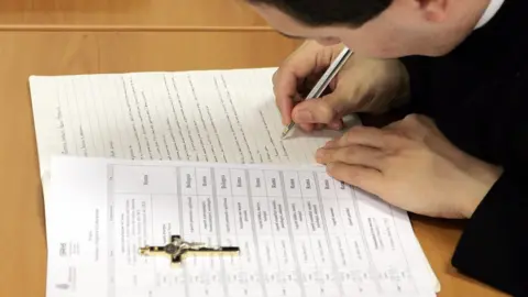 AFP A priest takes notes during the satanism and exorcism lesson at the Regina Apostolorum pontifical university in Rome, 17 February 2005