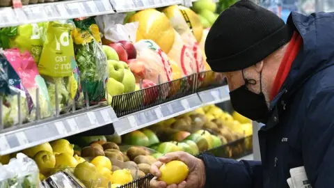 Getty Images A man chooses lemons at a supermarket in Moscow.