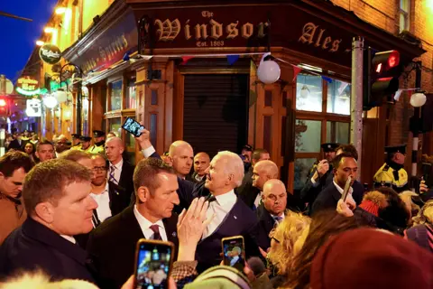 Kevin Lamarque / Reuters US President Joe Biden takes a selfie outside a pub in Dundalk, Ireland, on 12 April 2023