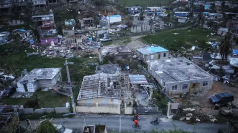 Getty Images Kids bike in an area without grid power or running water about two weeks after Hurricane Maria swept through the island on October 5, 2017 in San Isidro, Puerto Rico.