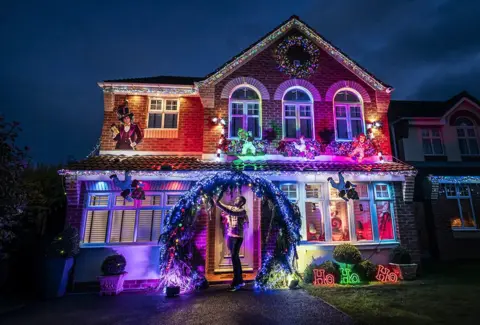 Danny Lawson / PA Media Michael Fenning puts the finish touches to his Wonka themed home in Doncaster, 8 December 2023