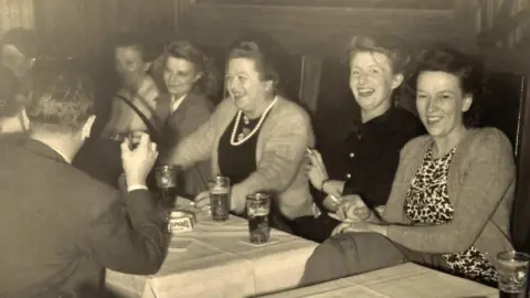 Vermeirsch family (Right to left) Selma van Gyseghem, Christina Helene Ardelheid Vermeirsch, Esther Vermeirsch and man (left with back to us) Albert van Gyseghem enjoying themselves at an unknown restaurant in Soho London in the early 1950's.