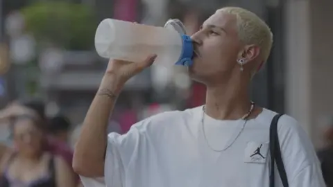 AFP A man drinks water on the street in Sao Paulo