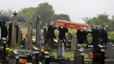 PA Mourners carry William Dunlop's coffin in the church cemetery