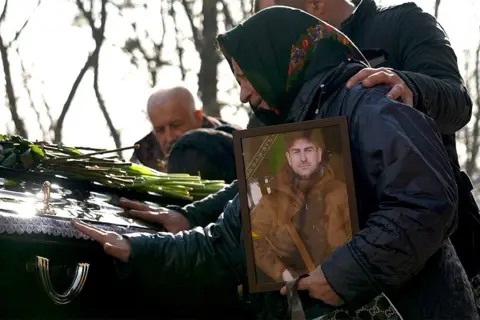 LEE DURANT/BBC Mother clutches a portrait of her soldier son