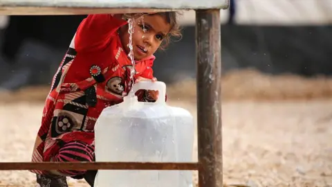 Getty Images A girl getting water from a tank