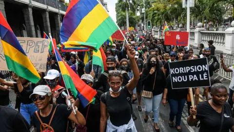 AFP Protesters march against the government's response to the oil spill disaster that happened in early August in front of Prime Minister's Office in Port Louis, on the island of Mauritius, on August 29, 2020.