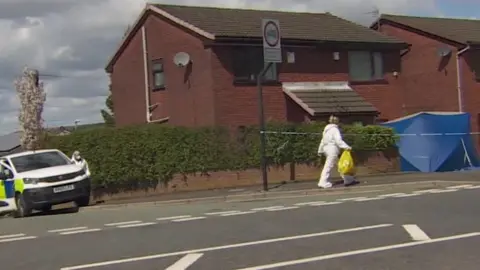 BBC Forensic police officers investigate a woman's death at a house