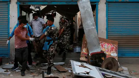 Reuters Security personnel remove a victim after an explosion in Kathmandu, Nepal May 26, 2019