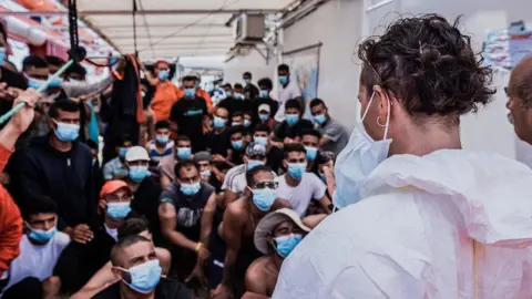 EPA/SOS MEDITERRANEE Migrants wearing masks onboard the Ocean Viking