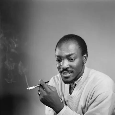 Roger DaSilva/Josef and Anni Albers Foundation Roger DaSilva poses for a self-timed photograph with a cigarette in hand.