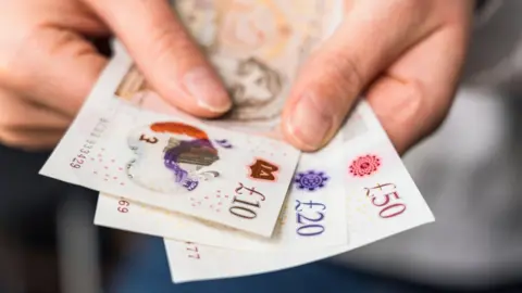 Getty Images Person holding money in their hand