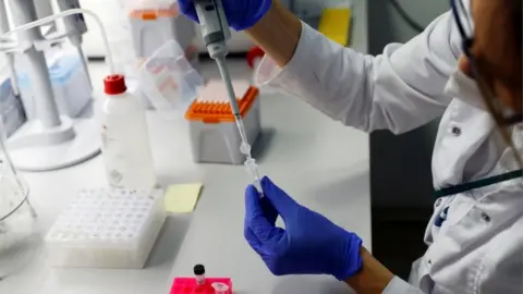 Reuters A laboratory worker works on fast PCR testing samples