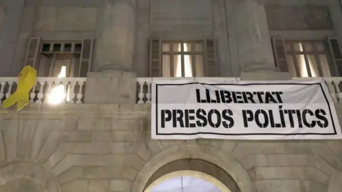 EPA A banner reading "Liberty for political prisoners" and a yellow bow are placed at front of the Barcelona City Hall