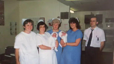 Family photo Medical staff with two of the triplets
