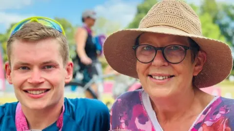 Angela Ramsell and her son Charlie outside smiling with a glass of fizz