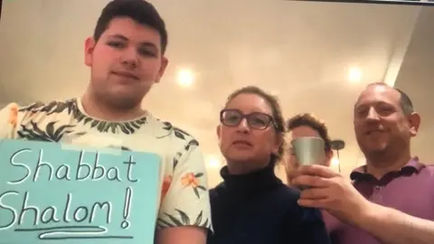 BBC Family holding a sign reading Shabbat Shalom