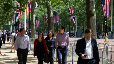 Getty Images People walk by US and UK flags