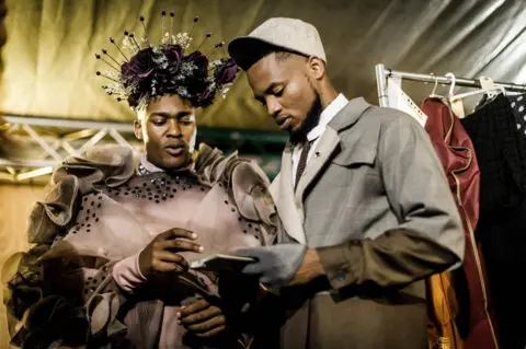 Getty Images Male models prepare backstage during the fashion preview and concert show for the pre-Durban July Handicap horse race on June 30, 2018 in Durban