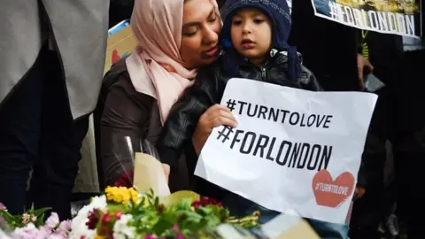 EPA Members of London's Muslim community hold signs of condolence and support near the site of an attack at Borough Market in London