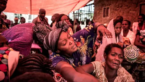 AFP Women react when they see the coffin of someone killed by the Ugandan Allied Democratic Forces(ADF) rebel group in Beni, DR Congo