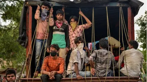 Getty Images Migrant workers who arrived from Maharashtra state travel on a mini truck to go back to their hometowns, after the government eased a nationwide lockdown imposed as a preventive measure against the COVID-19 coronavirus, in Allahabad on May 15, 2020.