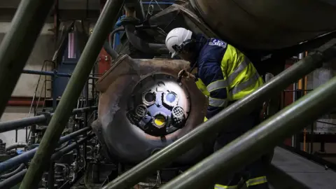 Guernsey Electricity A man performing a routine maintenance checks on one of the Sulzer 9RNF68 generators at the power station in Guernsey